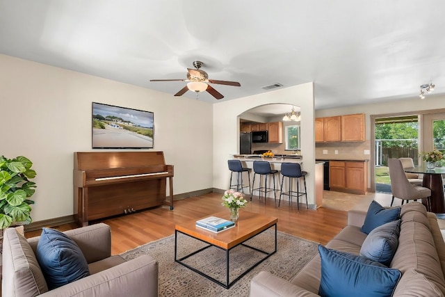 1203 Haynes St, San Marcos, TX 78666 - living area featuring light wood-style flooring, a ceiling fan, and arched walkways