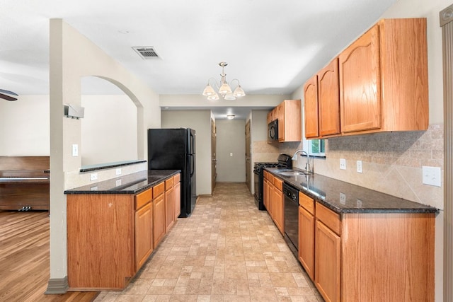 1203 Haynes St, San Marcos, TX 78666 - kitchen featuring black appliances, backsplash, a chandelier, dark stone countertops, and pendant lighting