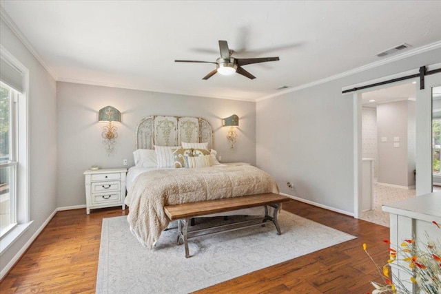 2901 Olympia Dr, Temple, TX 76502 - bedroom featuring a barn door, ornamental molding, multiple windows, and wood finished floors