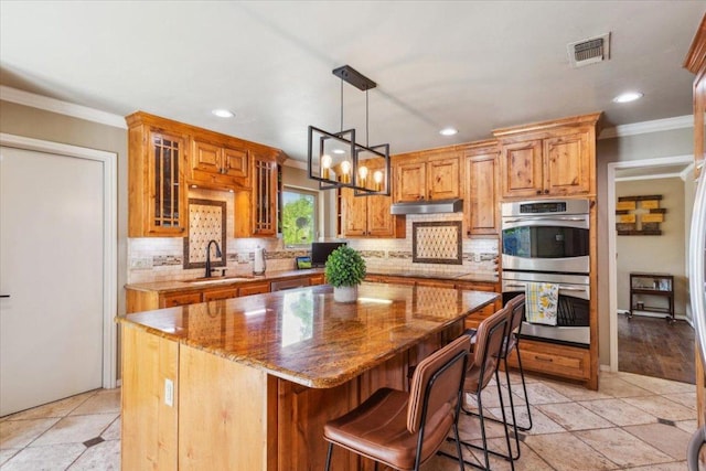 2901 Olympia Dr, Temple, TX 76502 - kitchen with double oven, a sink, ornamental molding, tasteful backsplash, and a kitchen island