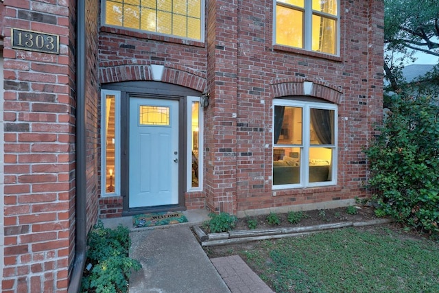 doorway to property featuring brick siding