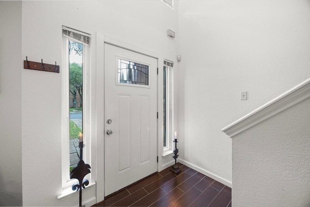 foyer entrance with baseboards and dark wood-style flooring
