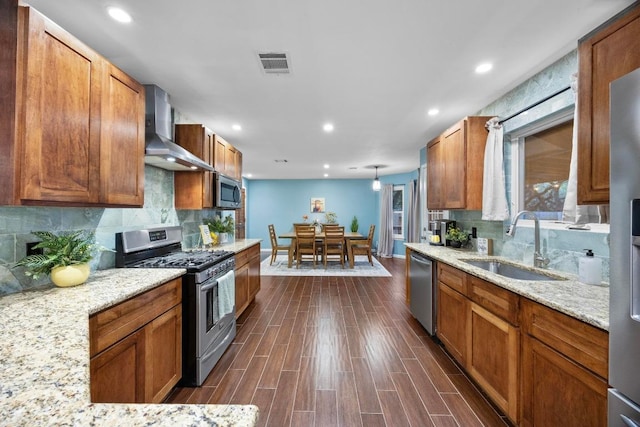 1303 Shady Grove Path, Cedar Park, TX 78613 - kitchen featuring stainless steel appliances, a sink, wall chimney exhaust hood, decorative backsplash, and brown cabinetry