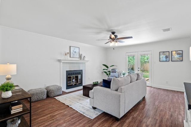 11708 Rotherham Dr, Austin, TX 78753 - living room with ceiling fan, dark wood-type flooring, a fireplace, ornamental molding, and french doors