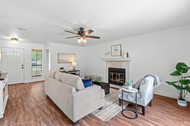 11708 Rotherham Dr, Austin, TX 78753 - living area featuring wood finished floors, a tiled fireplace, ornamental molding, and ceiling fan