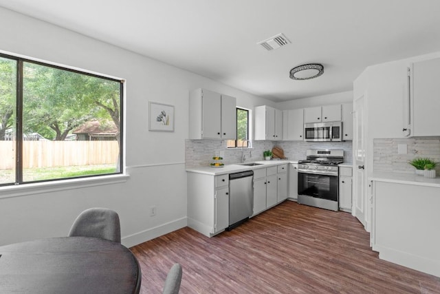 11708 Rotherham Dr, Austin, TX 78753 - kitchen featuring appliances with stainless steel finishes, tasteful backsplash, light countertops, and dark wood-type flooring