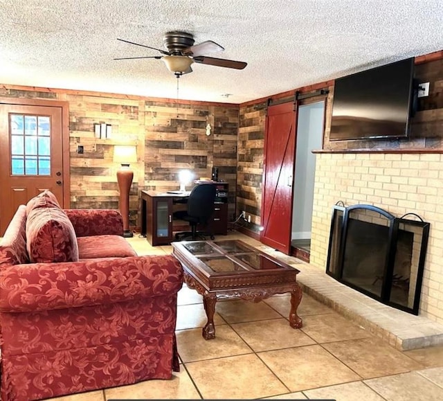101 Byrne St, Smithville, TX 78957 - living area featuring a ceiling fan, a textured ceiling, light tile patterned floors, wood walls, and a brick fireplace