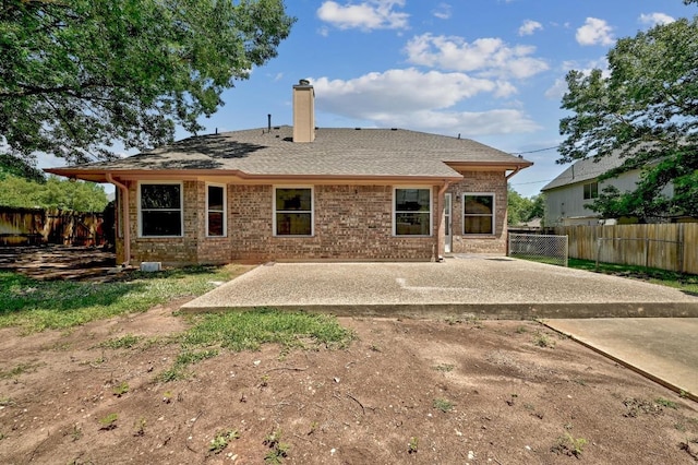 1605 Woods Blvd, Round Rock, TX 78681 - rear view of property featuring a chimney, a patio, and brick siding