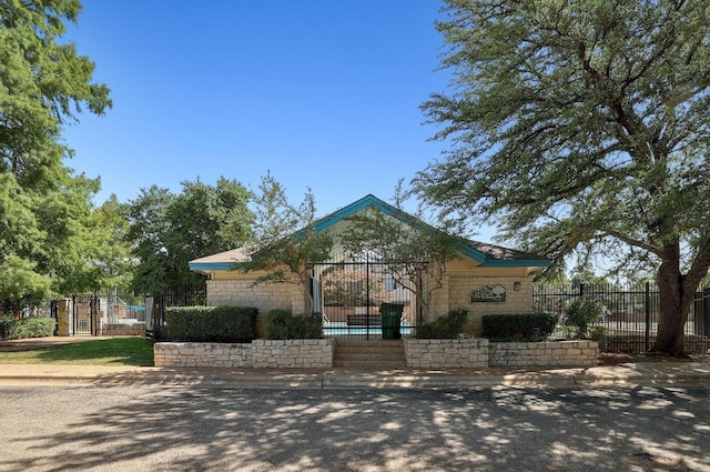 1605 Woods Blvd, Round Rock, TX 78681 - view of front of house with stone siding, fence, and a gate