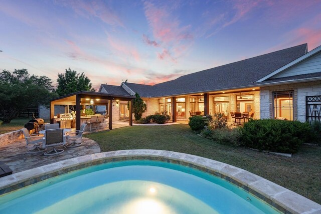 611 Post Oak Dr, Dripping Springs, TX 78620 - rear view of property with a lawn, a patio area, an outdoor pool, and an outdoor kitchen