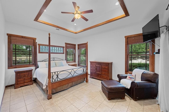 611 Post Oak Dr, Dripping Springs, TX 78620 - bedroom featuring multiple windows, a tray ceiling, light tile patterned floors, and a ceiling fan
