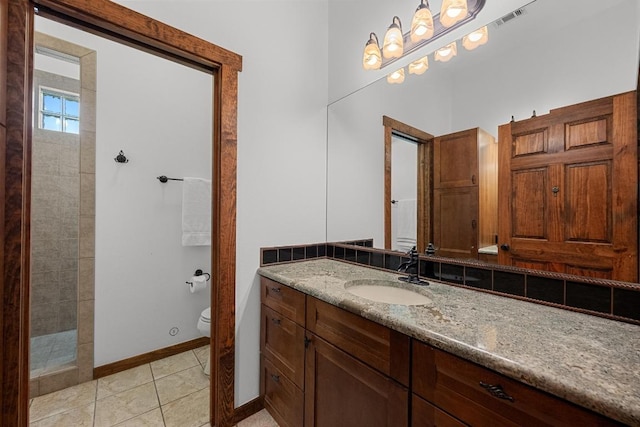 611 Post Oak Dr, Dripping Springs, TX 78620 - bathroom with a tile shower, baseboards, toilet, vanity, and tile patterned floors