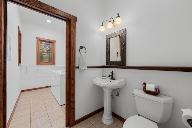 611 Post Oak Dr, Dripping Springs, TX 78620 - bathroom with washing machine and clothes dryer, tile patterned flooring, toilet, and a sink
