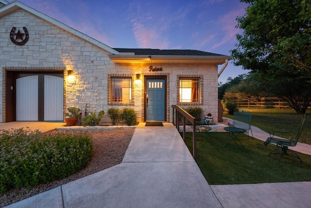 611 Post Oak Dr, Dripping Springs, TX 78620 - view of front of home featuring stone siding, a front lawn, and a garage