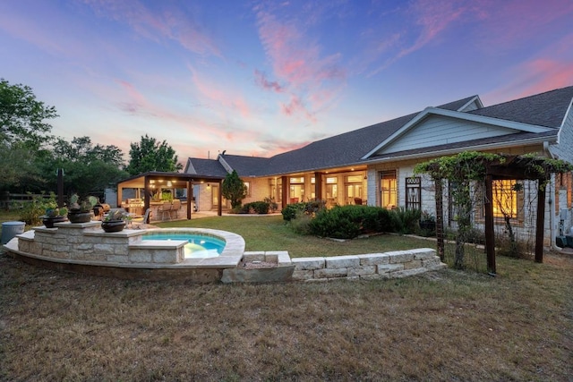 611 Post Oak Dr, Dripping Springs, TX 78620 - back of house at dusk with an in-ground hot tub, a yard, and a patio