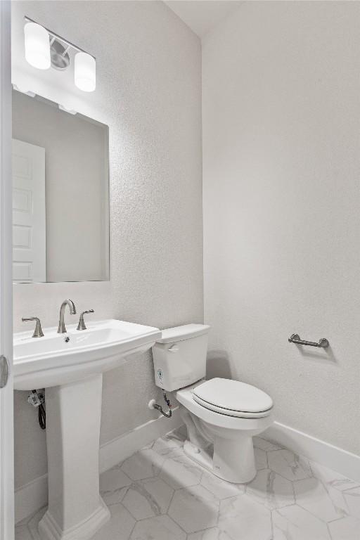 422 Sitlington Ln, Austin, TX 78738 - half bath featuring baseboards, marble finish floors, toilet, and a textured wall