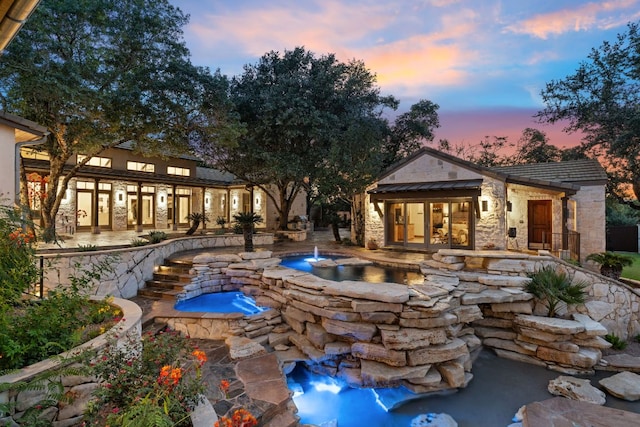 11949 Overlook Pass, Austin, TX 78738 - pool at dusk featuring an in-ground hot tub, french doors, and a patio