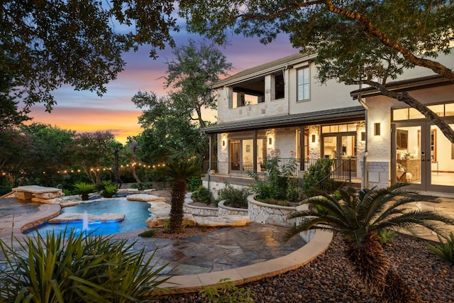 11949 Overlook Pass, Austin, TX 78738 - back of house with french doors, stone siding, an outdoor pool, stucco siding, and a patio area