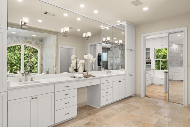 11949 Overlook Pass, Austin, TX 78738 - full bath with double vanity, stone tile flooring, and recessed lighting