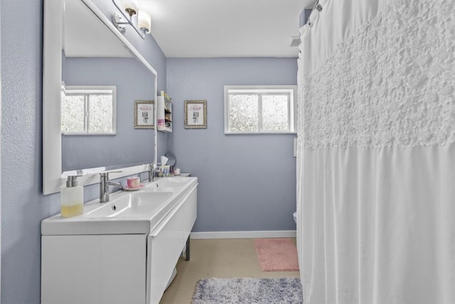 726 Mesa Dr, Del Valle, TX 78617 - full bathroom featuring healthy amount of natural light, vanity, finished concrete flooring, and baseboards