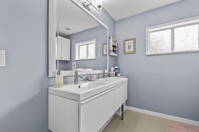 726 Mesa Dr, Del Valle, TX 78617 - bathroom with finished concrete floors, baseboards, and double vanity