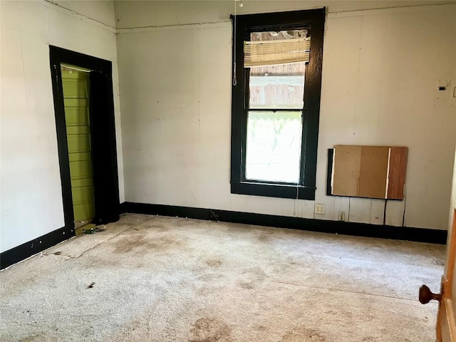unfurnished room with carpet floors and baseboards