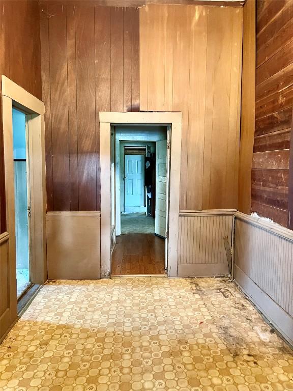 hallway featuring wood walls