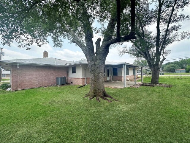 419 N Knox Ave, Giddings, TX 78942 - back of house with cooling unit, a patio area, brick siding, and a chimney