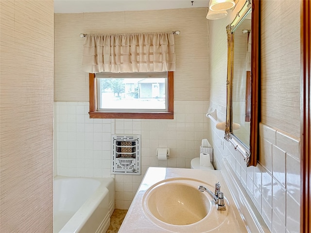 419 N Knox Ave, Giddings, TX 78942 - bathroom featuring heating unit, a bathtub, tile walls, toilet, and vanity