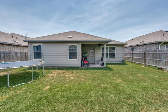 299 Andesite Trl, Buda, TX 78610 - back of property featuring a trampoline and a patio area