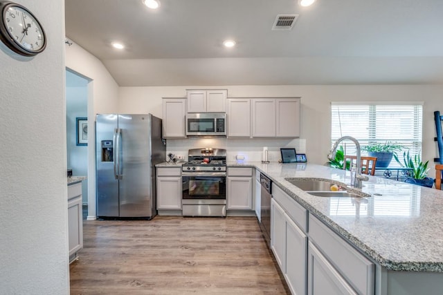 299 Andesite Trl, Buda, TX 78610 - kitchen with stainless steel appliances, a sink, a peninsula, light wood-style floors, and recessed lighting