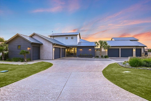 116 Wennmohs Pl, Horseshoe Bay, TX 78657 - view of front facade featuring a standing seam roof, driveway, metal roof, a lawn, and stucco siding
