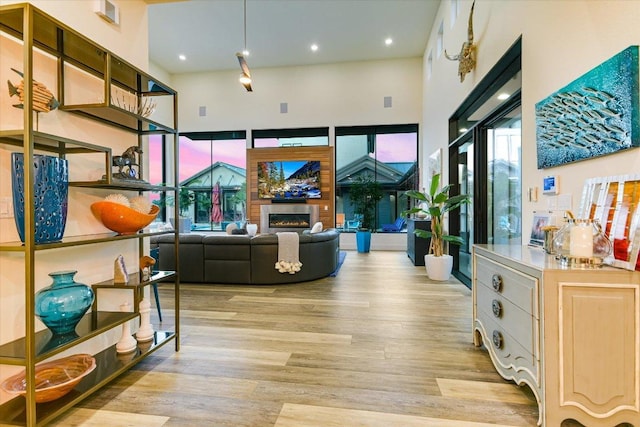 116 Wennmohs Pl, Horseshoe Bay, TX 78657 - living area featuring wood finished floors, a glass covered fireplace, a towering ceiling, and recessed lighting