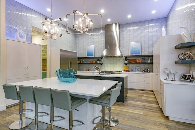 116 Wennmohs Pl, Horseshoe Bay, TX 78657 - kitchen with open shelves, wall chimney range hood, a center island with sink, light countertops, and decorative backsplash