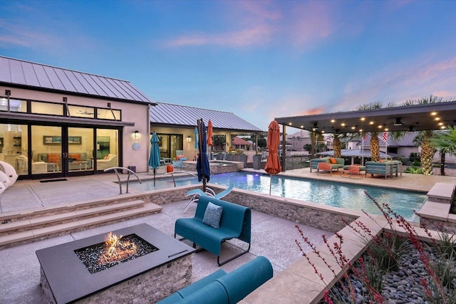 116 Wennmohs Pl, Horseshoe Bay, TX 78657 - pool at dusk featuring an outdoor living space with a fire pit, a patio, an outdoor pool, and an in-ground hot tub