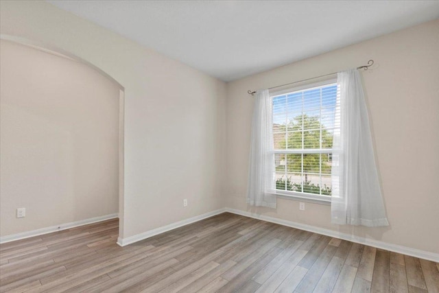 321 Freedom Park Ave, Liberty Hill, TX 78642 - empty room featuring light wood-style floors, baseboards, and arched walkways
