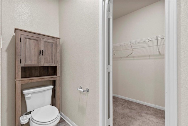 321 Freedom Park Ave, Liberty Hill, TX 78642 - bathroom featuring toilet, a walk in closet, and baseboards