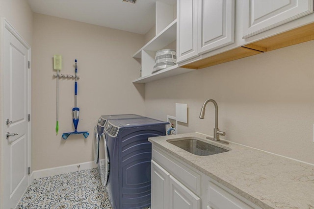 laundry room with cabinet space, baseboards, washing machine and dryer, and light tile patterned floors