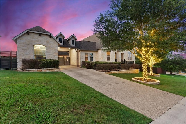 french country inspired facade with stone siding and concrete driveway