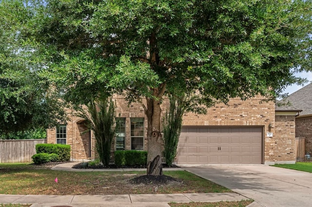 2640 Estefania Ln, Round Rock, TX 78665 - view of property hidden behind natural elements featuring brick siding, driveway, and a garage