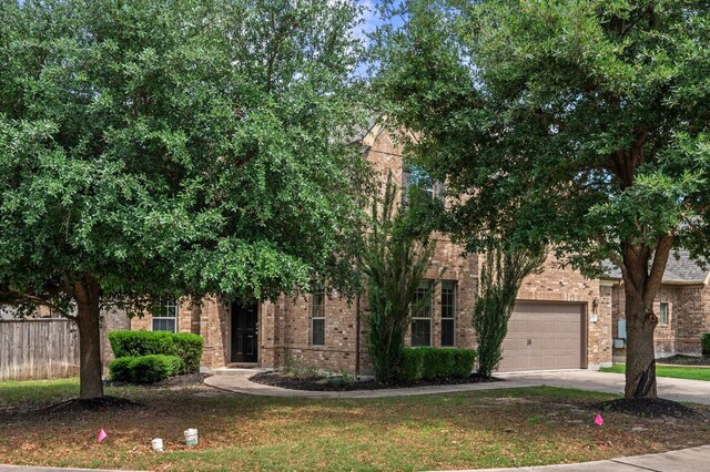 2640 Estefania Ln, Round Rock, TX 78665 - obstructed view of property featuring brick siding, driveway, and a garage