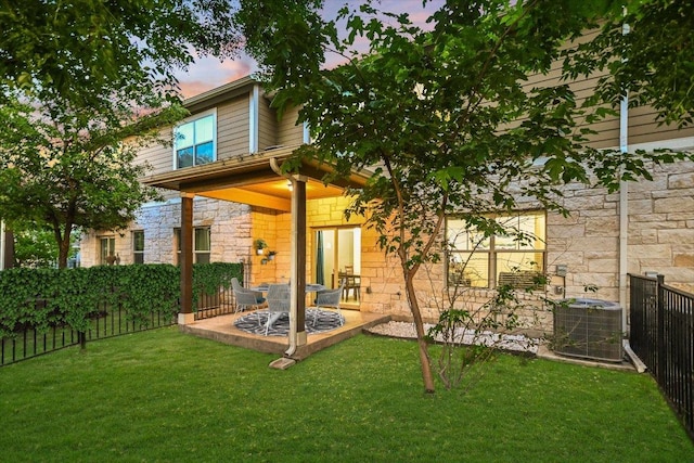 516 E Slaughter Ln Unit 1203, Austin, TX 78744 - back of house at dusk featuring stone siding, cooling unit, and a patio