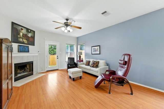 9403 Brandts Wood St, Austin, TX 78744 - living area featuring a ceiling fan, light wood-style flooring, and a tiled fireplace