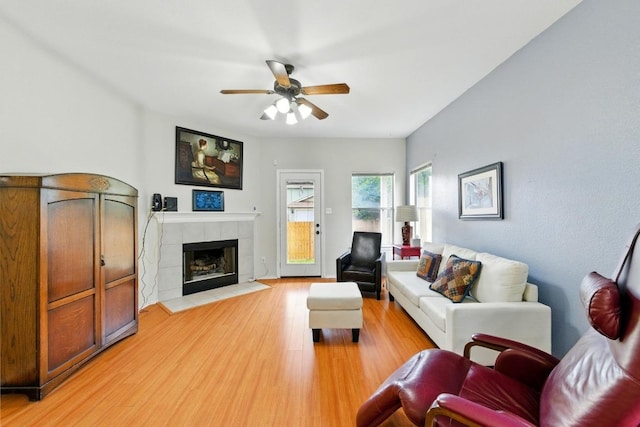9403 Brandts Wood St, Austin, TX 78744 - living room with ceiling fan, light wood-style flooring, and a tile fireplace