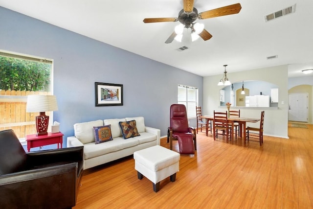 9403 Brandts Wood St, Austin, TX 78744 - living room with light wood finished floors, a ceiling fan, and arched walkways