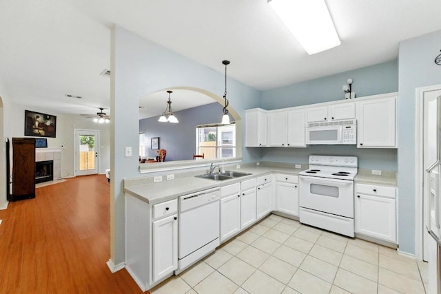 9403 Brandts Wood St, Austin, TX 78744 - kitchen featuring white appliances, light countertops, arched walkways, and plenty of natural light