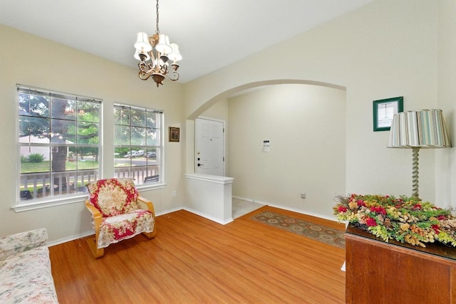 9403 Brandts Wood St, Austin, TX 78744 - living area with arched walkways, wood finished floors, and a chandelier