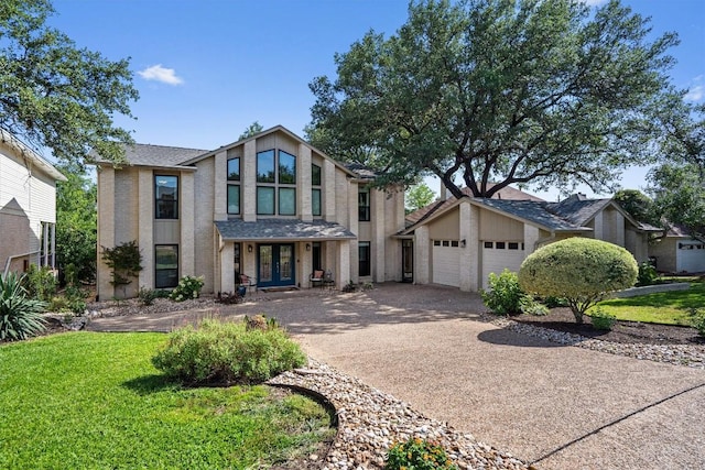 5503 Courtyard Dr, Austin, TX 78731 - mid-century home featuring concrete driveway, french doors, an attached garage, a front lawn, and brick siding