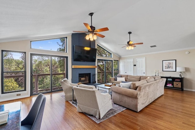 5503 Courtyard Dr, Austin, TX 78731 - living room featuring wood finished floors, healthy amount of natural light, a ceiling fan, a fireplace, and crown molding