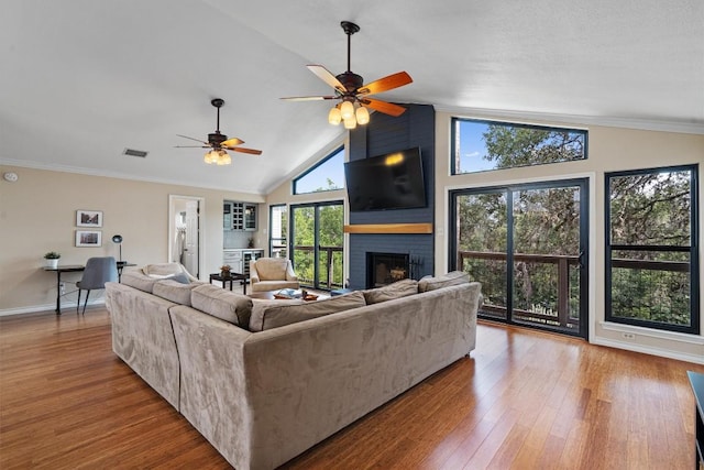 5503 Courtyard Dr, Austin, TX 78731 - living area featuring a fireplace, wood finished floors, ceiling fan, baseboards, and high vaulted ceiling